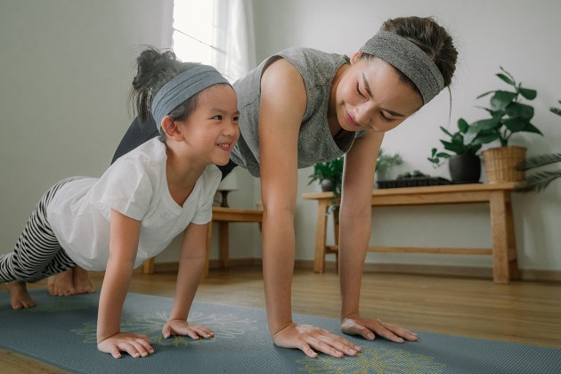 A parent practicing yoga with their child.