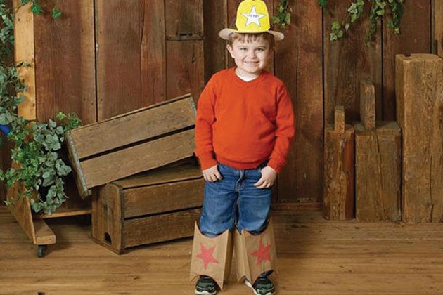 Child smiling while wearing homemade cowboy boots and cowboy hat.