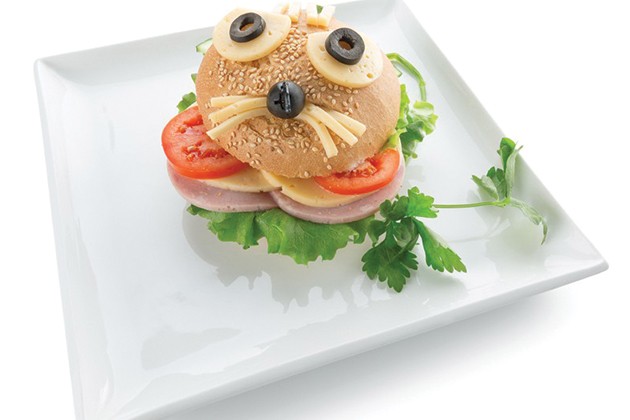 A sandwich with the top bun decorated to look like a face.