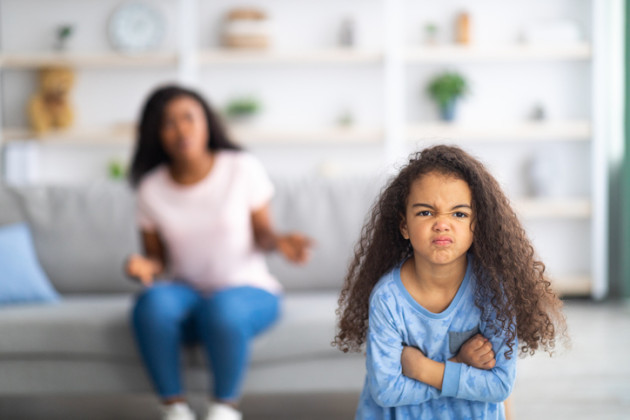 Little girl with arms crossed, angry at her mom.